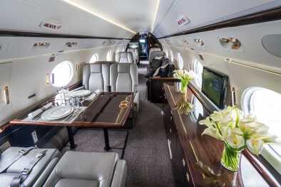 El interior de un espacioso jet privado , con flores y mesas de comedor