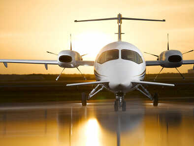 Vista frontal de un Piaggio P.180 Avanti en el aeropuerto al atardecer Vista frontal de un Piaggio P.180 Avanti en el aeropuerto al atardecer