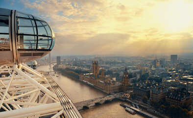 Aerial view to the illuminated Tower Bridge and skyline of London, UK, just after sunset
