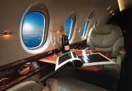 luxury interior in the modern business jet and sunlight at the window/sky and clouds through the porthole luxury interior in the modern business jet and sunlight at the window/sky and clouds through the porthole