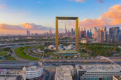Vista aérea de Dubai Frame, el horizonte del centro, los Emiratos Árabes Unidos o los EAU. Distrito financiero y zona de negocios en ciudad urbana inteligente. Rascacielos y edificios altos al atardecer.
