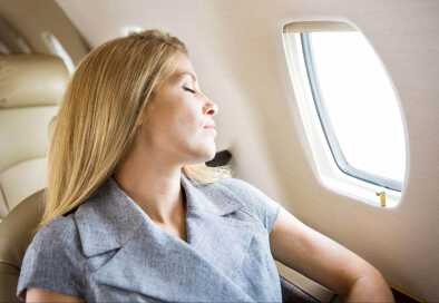 Mujer en un jet privado disfrutando de un relajante viaje Mujer en un jet privado disfrutando de un relajante viaje