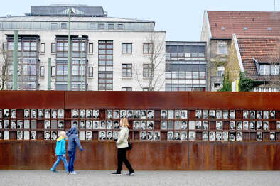 Monumento del Muro de Berlín con fotos de personas y visitantes. Rememorando la catástrofe y holocausto de la guerra mundial en alemania