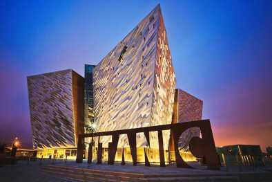 BELFAST, IRLANDA DEL NORTE - Puesta de sol sobre Titanic Belfast - museo, atracción turística y monumento al patrimonio marítimo de Belfast en el sitio del antiguo astillero Harland and Wolff.