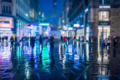 Folla di persone anonime che cammina per le strade notturne della città di Vienna, molto trafficate
