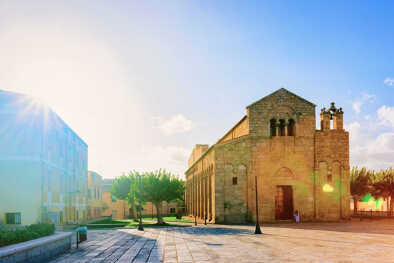 Basilica di San Simplicio Church in Old city of Olbia on Sardinia Island in Italy. Square with street lanterns and Cathedral in Sardegna island. Blue sky and sunlight Basilica di San Simplicio Church in Old city of Olbia on Sardinia Island in Italy. Square with street lanterns and Cathedral in Sardegna island. Blue sky and sunlight