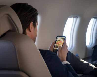 A businessman browsing his phone on a private jet