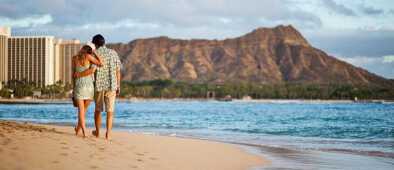 Una pareja caminando por la playa de waikiki Una pareja caminando por la playa de waikiki