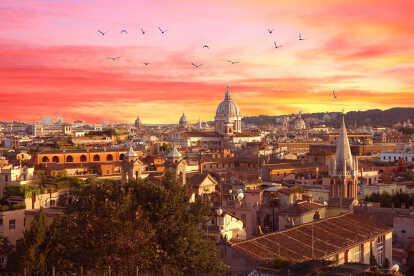 Veduta di Roma con il Colosseo a sinistra e il tramonto sullo sfondo