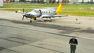 View of the runaway at the Sion airport with a Pilatus PC-12  and a pilot walking away