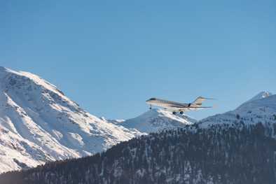 Un jet privato che vola a distanza ravvicinata sulle montagne innevate