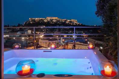 una piscina con vista su una città e un grande edificio sullo sfondo nell'hotel a for atehns una piscina con vista su una città e un grande edificio sullo sfondo nell'hotel a for atehns
