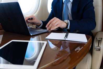 A business man working on a laptop on a private jet