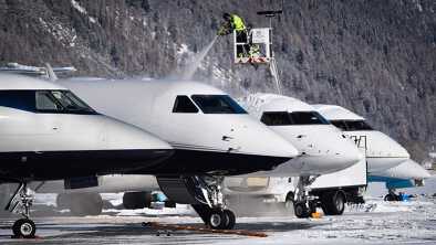 A man removing the ice on the top of an aircraft. This operation is called deicing de-icing