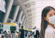 Passagier in einer Flughafen-Lounge, der eine Anti-COVID19-Gesichtsmaske tragt Passagier in einer Flughafen-Lounge, der eine Anti-COVID19-Gesichtsmaske tragt